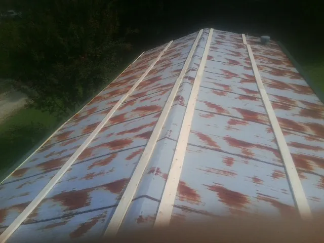 Rusted metal roof panels with new wood purlins before replacement — Storm Damage Roof Repair in Strafford by Roofing Brothers