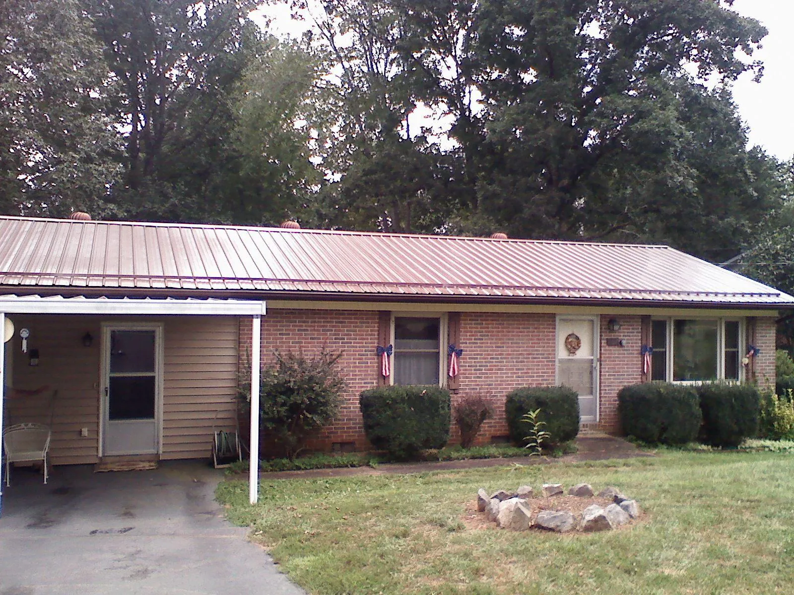 Bronze metal roof and carport on a brick ranch home — Roof Repair work by our crew in Strafford